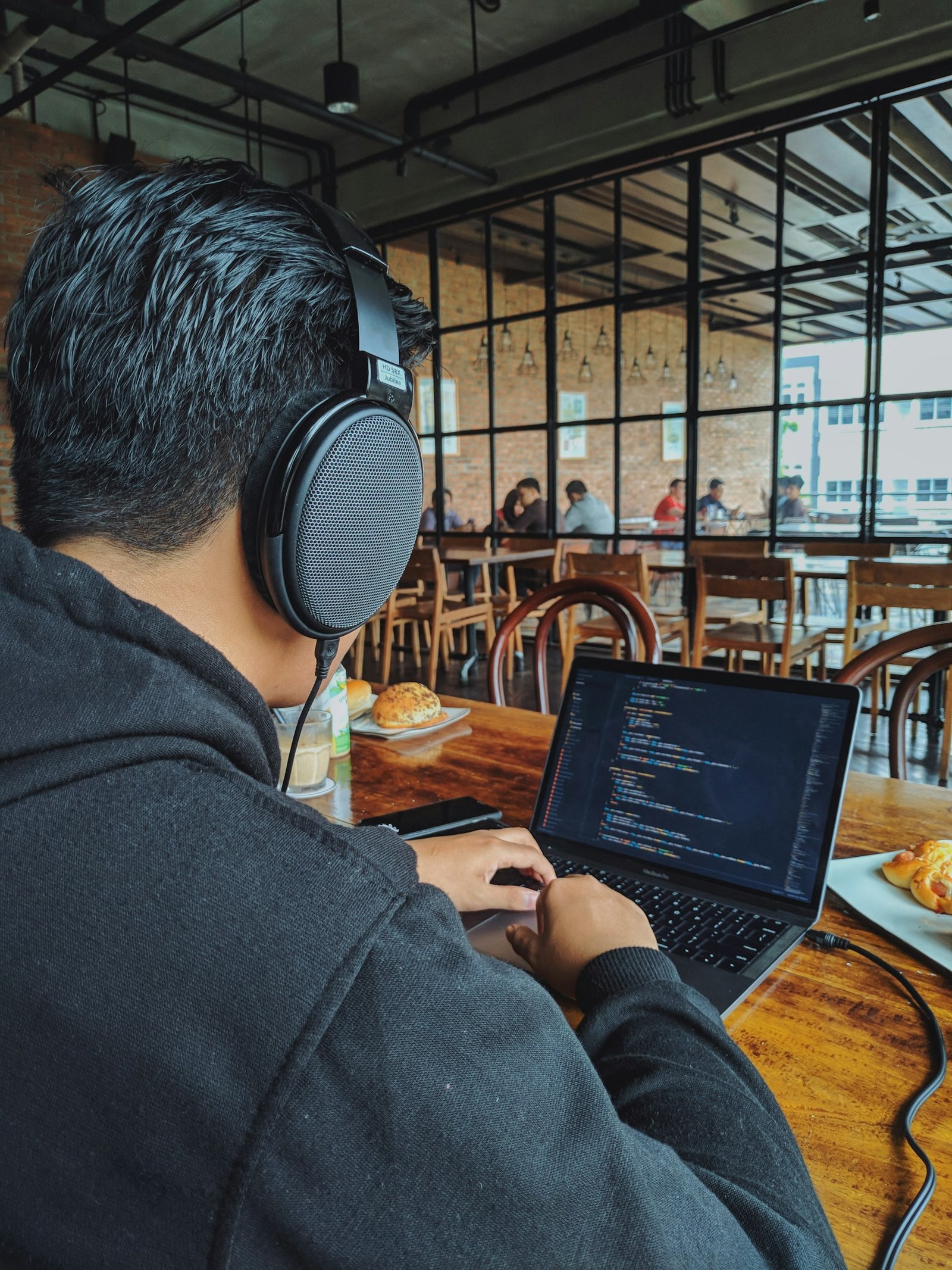 A man working at a laptop at a table in a cafe